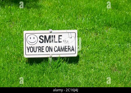 Lächeln Sie`re auf Kamera-Schild auf einem Rasen. Stockfoto